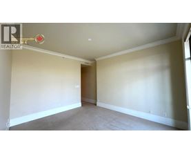 A room with a carpeted floor and a doorway leading to another room.