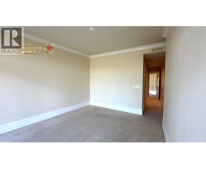 A spacious room with a carpeted floor and white walls.