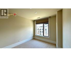 A room with a window showing a view of a building outside.