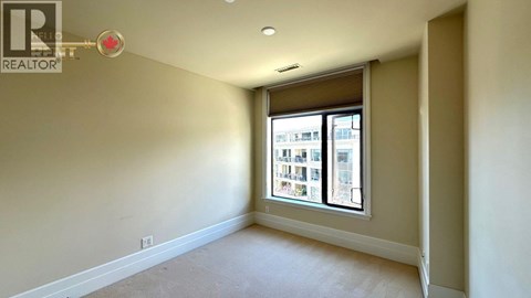 A room with a window showing a view of a building outside.