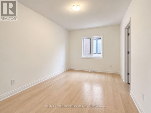 A room with a window and wooden flooring.