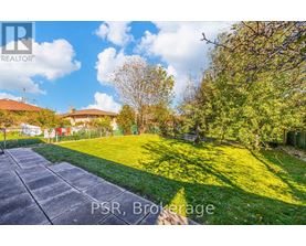 A sunny day in Brokerage with a house and trees in the background.