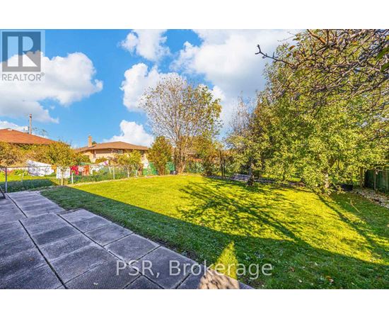 A sunny day in Brokerage with a house and trees in the background.