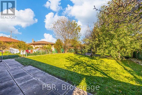 A sunny day in Brokerage with a house and trees in the background.
