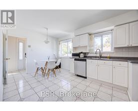 A kitchen with white cabinets and a black dishwasher.
