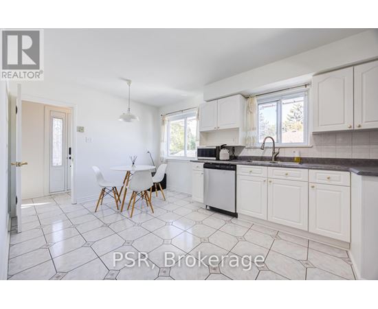 A kitchen with white cabinets and a black dishwasher.
