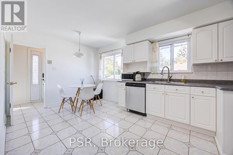 A kitchen with white cabinets and a black dishwasher.