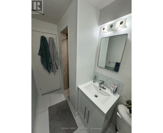 A white bathroom with a sink, mirror, and towel rack.