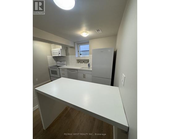 A white kitchen with a counter top in the foreground.