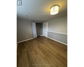 A bedroom with a wooden floor and a white door.