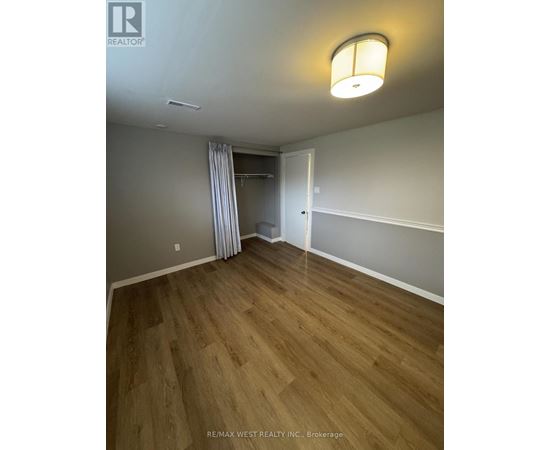 A bedroom with a wooden floor and a white door.