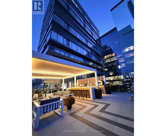 A modern outdoor seating area with a bar and comfortable seating.