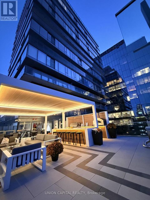 A modern outdoor seating area with a bar and comfortable seating.
