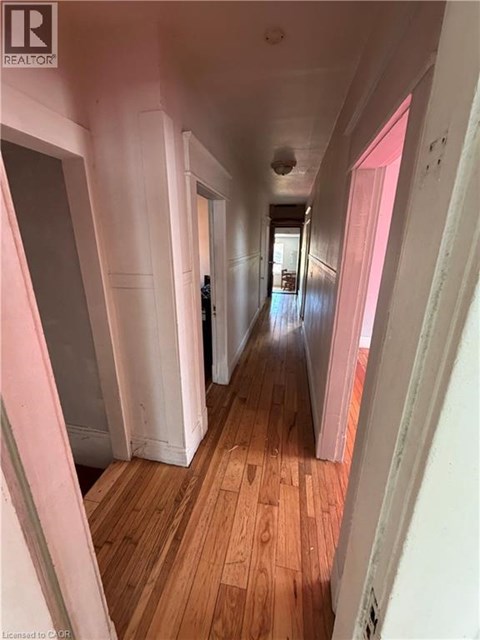A long hallway with wooden floors and white walls.
