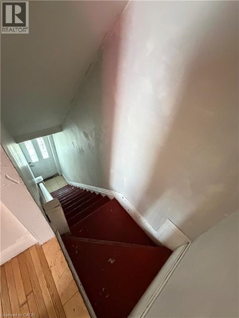 A staircase with wooden steps and a red carpet.
