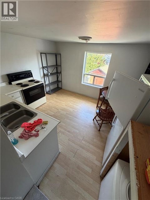 A kitchen with a sink, stove, and a window.