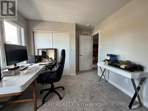 A room with a desk, chair, and a mirror.