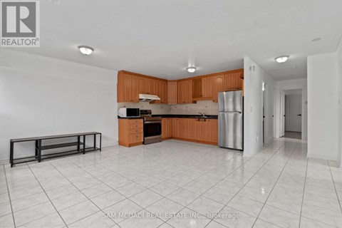 A kitchen with white tiled floors and wooden cabinets.
