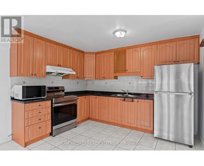 A kitchen with wooden cabinets and a refrigerator.