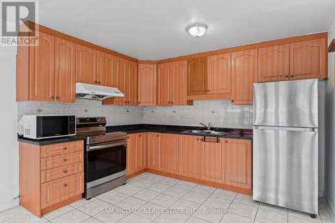 A kitchen with wooden cabinets and a refrigerator.