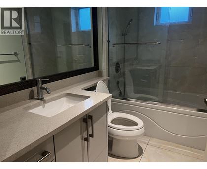 A bathroom with a toilet, sink, and bathtub.