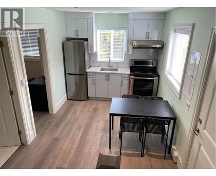 A kitchen with a table and chairs in front of a window.