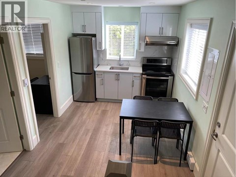A kitchen with a table and chairs in front of a window.