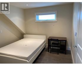 A bedroom with a bed, desk, and chair.