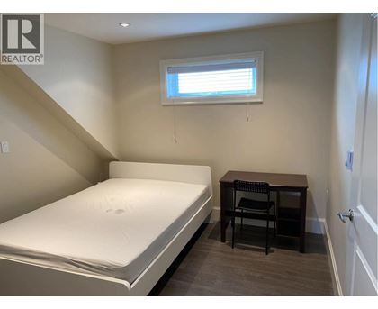 A bedroom with a bed, desk, and chair.