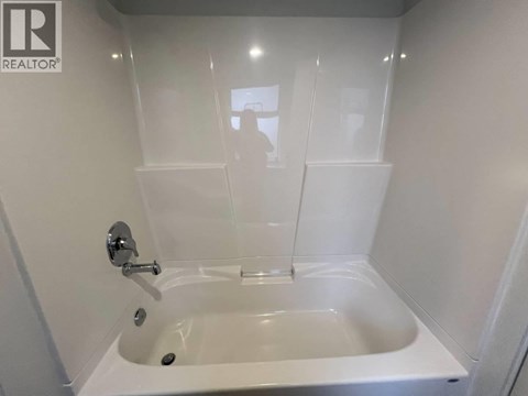 A white bathtub with a silver faucet in a bathroom.