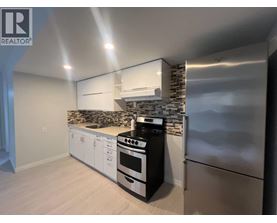 A modern kitchen with stainless steel appliances and white cabinets.