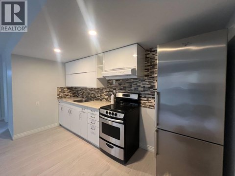 A modern kitchen with stainless steel appliances and white cabinets.