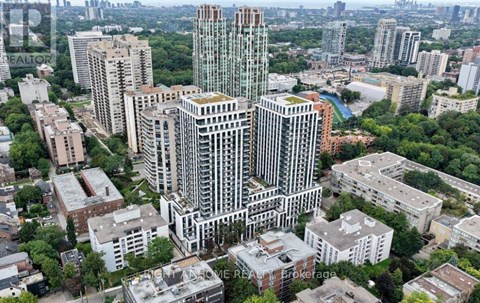 A cityscape with a mix of modern and older buildings, with a large green space in the foreground.