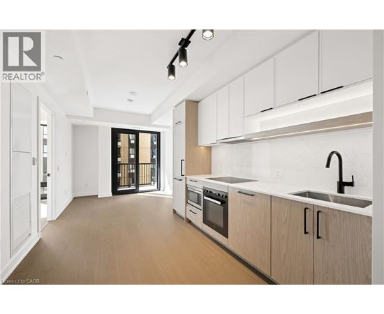 A modern kitchen with white cabinets and a black faucet.