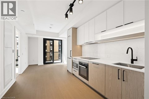 A modern kitchen with white cabinets and a black faucet.