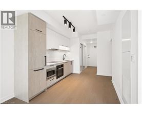 A modern kitchen with wooden floors and white walls.