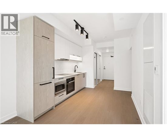 A modern kitchen with wooden floors and white walls.