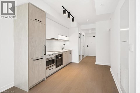A modern kitchen with wooden floors and white walls.