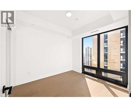 A large empty room with a view of a building outside the window.