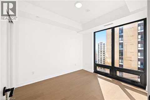 A large empty room with a view of a building outside the window.