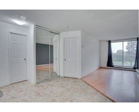 A room with a sliding glass door leading to a balcony.