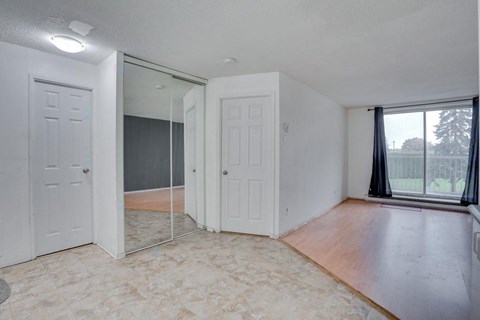 A room with a sliding glass door leading to a balcony.