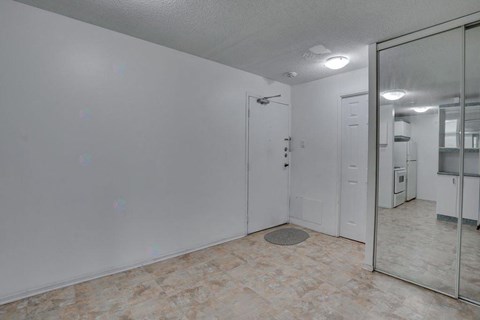 A room with a door and a mirror on the wall.