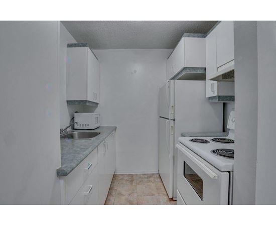A kitchen with white cabinets and a white oven.