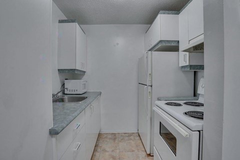A kitchen with white cabinets and a white oven.
