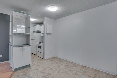 A kitchen with white cabinets and a tiled floor.
