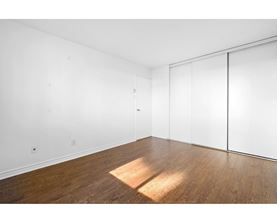 A room with a white wall and a wooden floor.