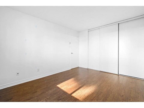 A room with a white wall and a wooden floor.