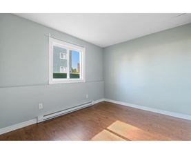 A room with a window showing a building outside.