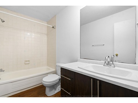 A white bathroom with a toilet, sink, and bathtub.